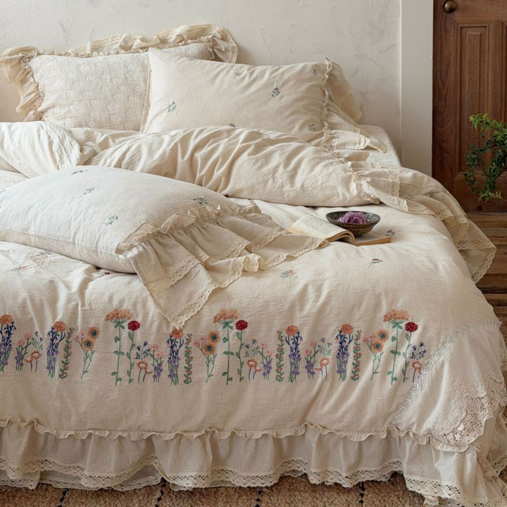 Romantic linen-cotton bedding set with embroidered floral border and ruffle
