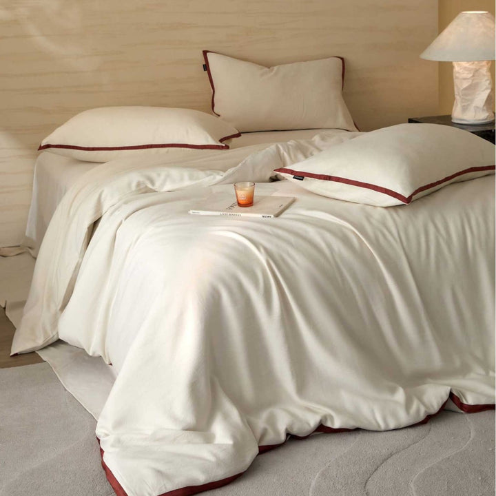 Stonewashed cotton bed linen set with contrasting piping and soft touch