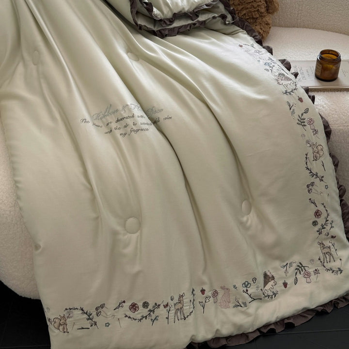 Quilted reversible duvet cover with floral embroidery and ruffled hem