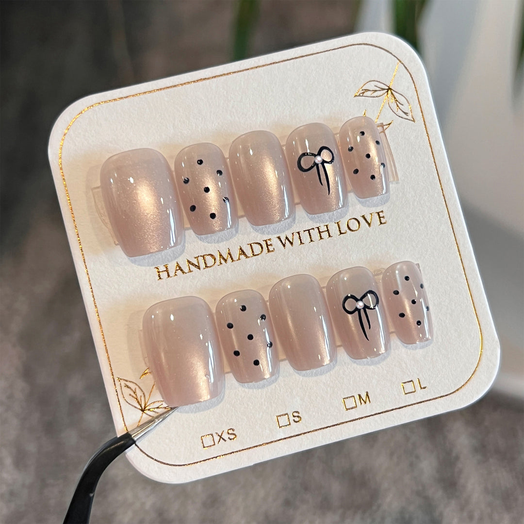 Artificial nail extensions with decorative bows and dots Kalsten