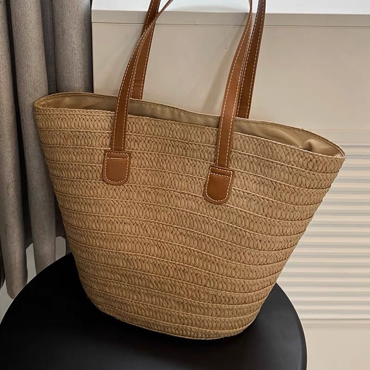 Stylish beach bag made of woven natural material with leather handles Kalsten