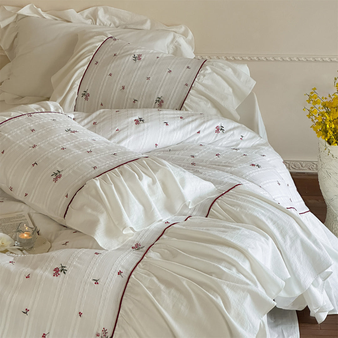 Cotton muslin bedding set with embroidered striped relief, gathered ruffle and fine piping