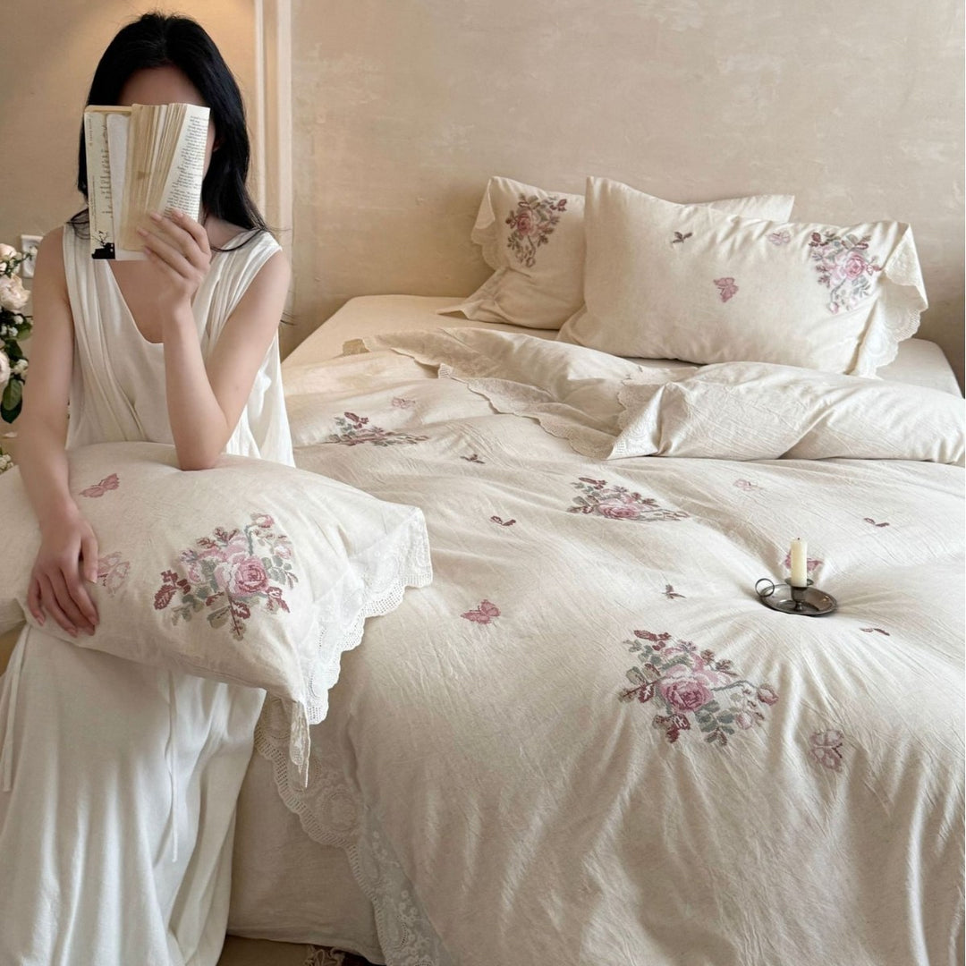 Embroidered cotton-linen bedding set with rose motifs, lace ruffle, and natural texture