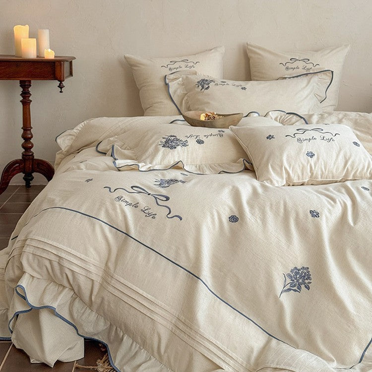 Cotton muslin bedding set with delicate floral embroidery, ruffle, and breathable finish
