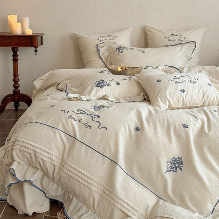 Cotton muslin bedding set with delicate floral embroidery, ruffle, and breathable finish