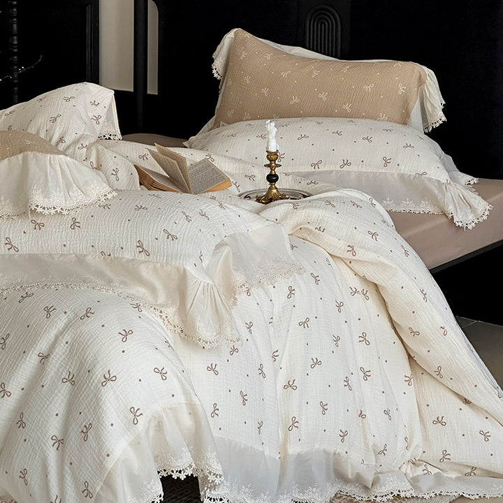 Cotton muslin bedding set with ruffles, lace trim, and delicate bow print