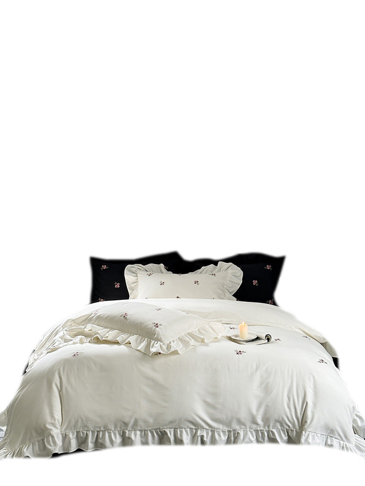 Elegant bed linen set made of breathable cotton satin with delicate floral embroidery and ruffled hem
