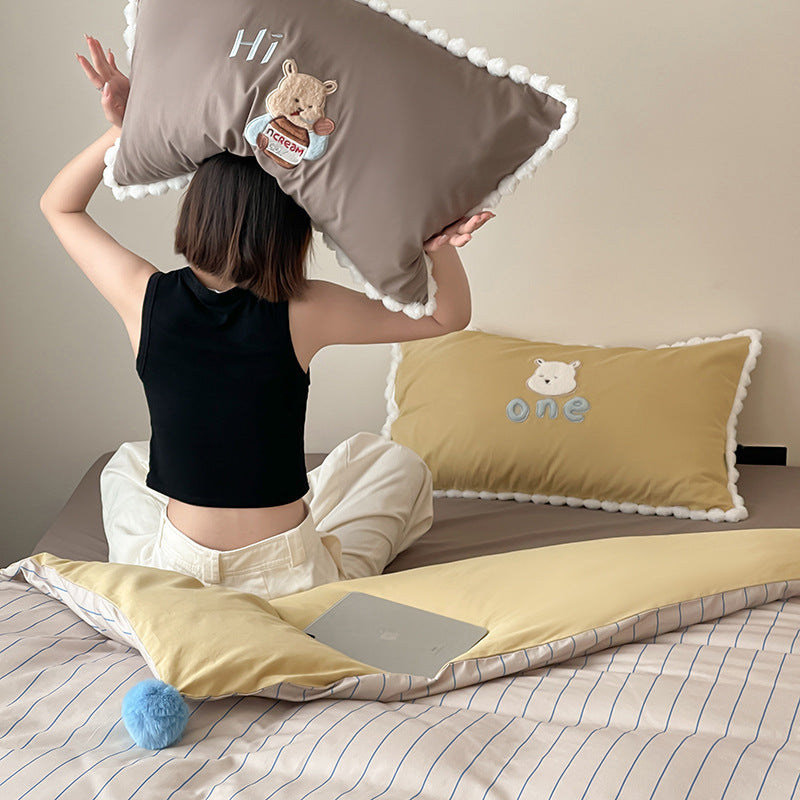 Children's bed set with teddy bear embroidery, pom-pom edging, and reversible blanket