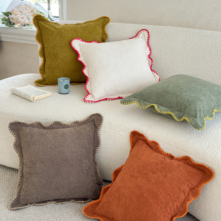 Decorative velvet cushion with wavy edge and decorative stitching