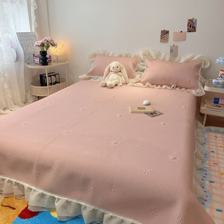 Quilted bedspread with ruffle and delicate floral quilting