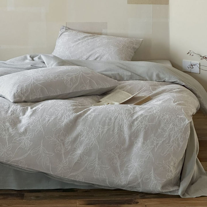 Finely woven cotton bedding set with embroidered floral relief and reversible cover