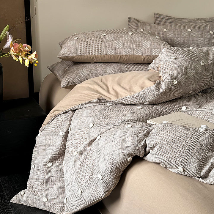 Luxurious cotton bedding set with textured waffle appearance and pompom details
