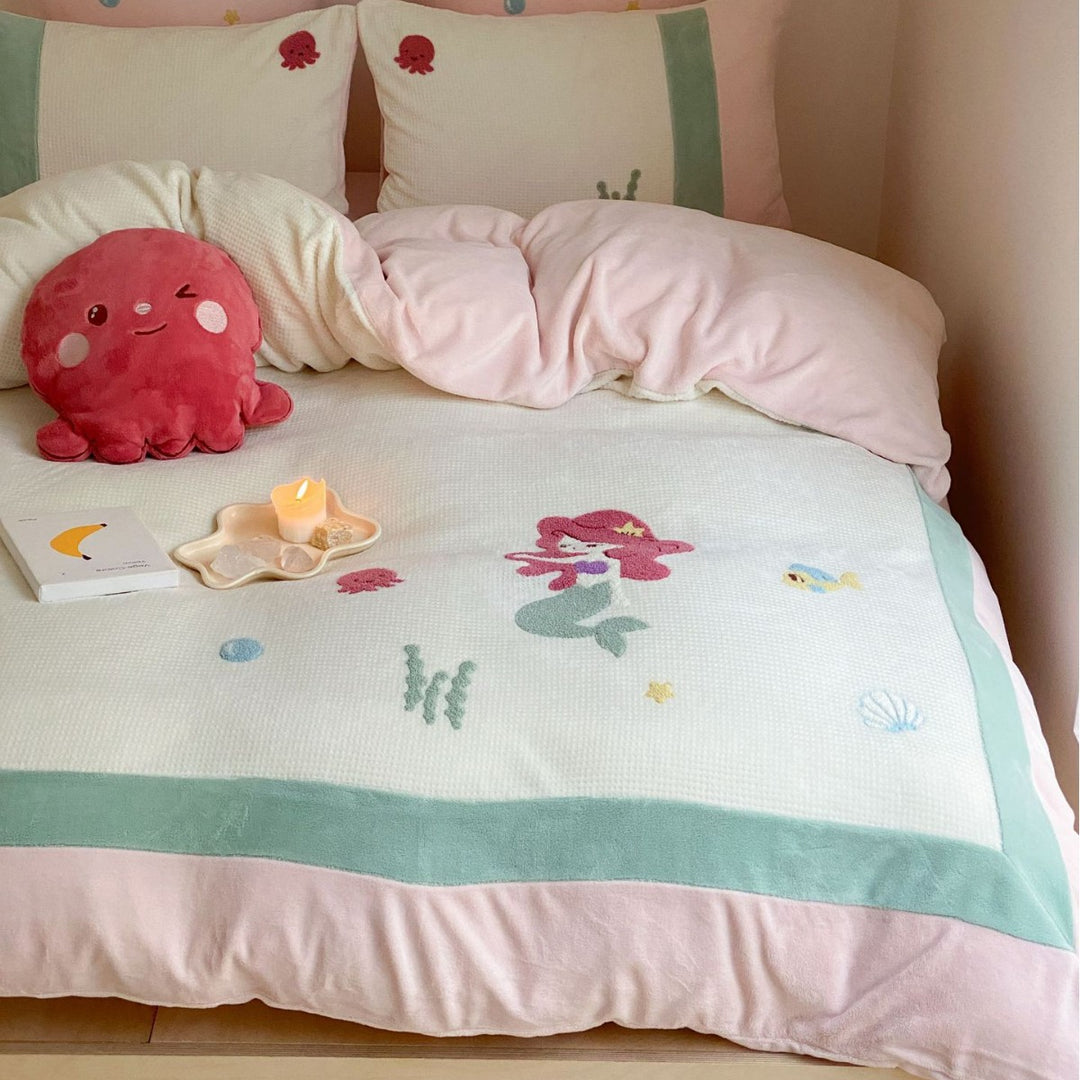 Cozy bedding set with plush border, embroidered appliqués, and reversible function