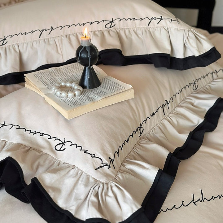 Luxurious cotton satin bedding set with ruffle, contrasting piped trim, and calligraphic embroidery