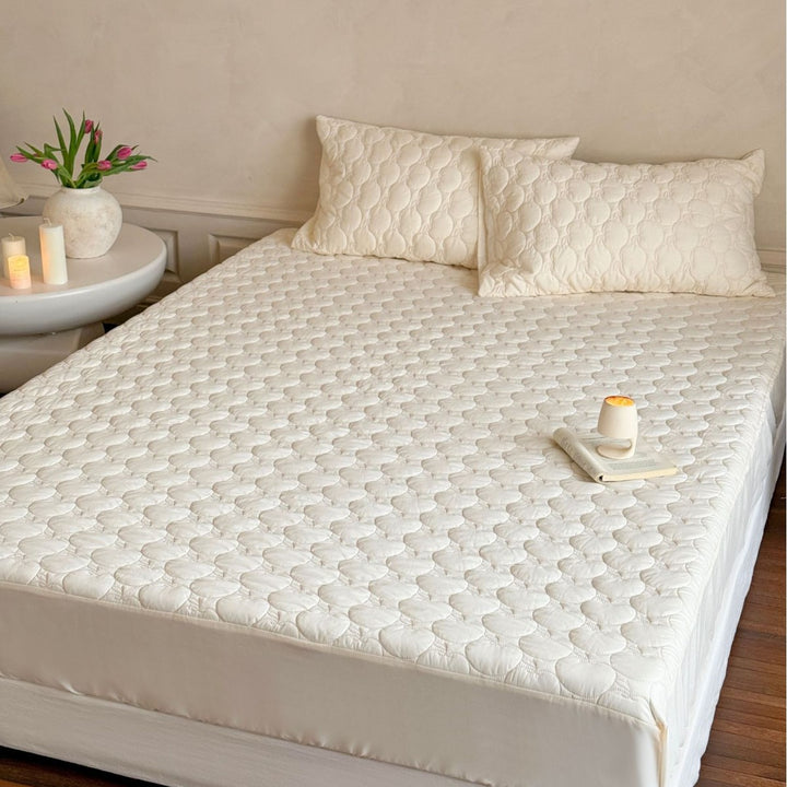 Padded mattress protector with quilted comfort layer and all-around elastic band