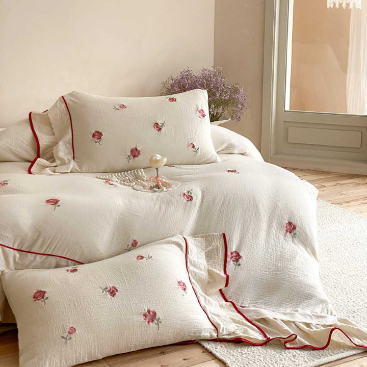 Bedding set made of cotton percale with frill hem, floral embroidery, and decorative ribbons