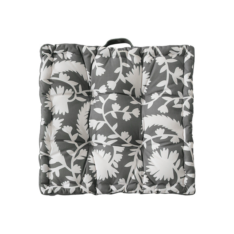 Padded floor cushion with quilted tufting, floral motif and carrying handle