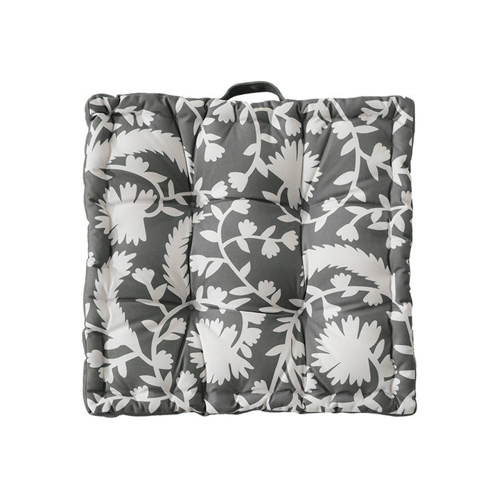 Padded floor cushion with quilted tufting, floral motif and carrying handle