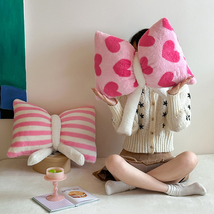 Cuddle cushion in bow shape made of plush with striped texture
