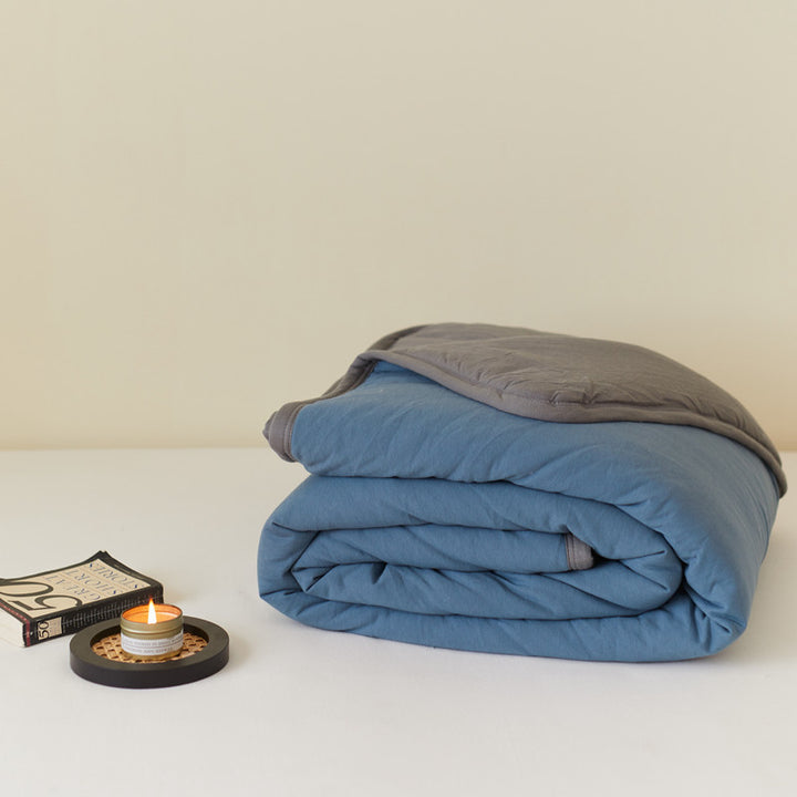 Ultralight climate-regulating quilted blanket with compact filling and cotton surface