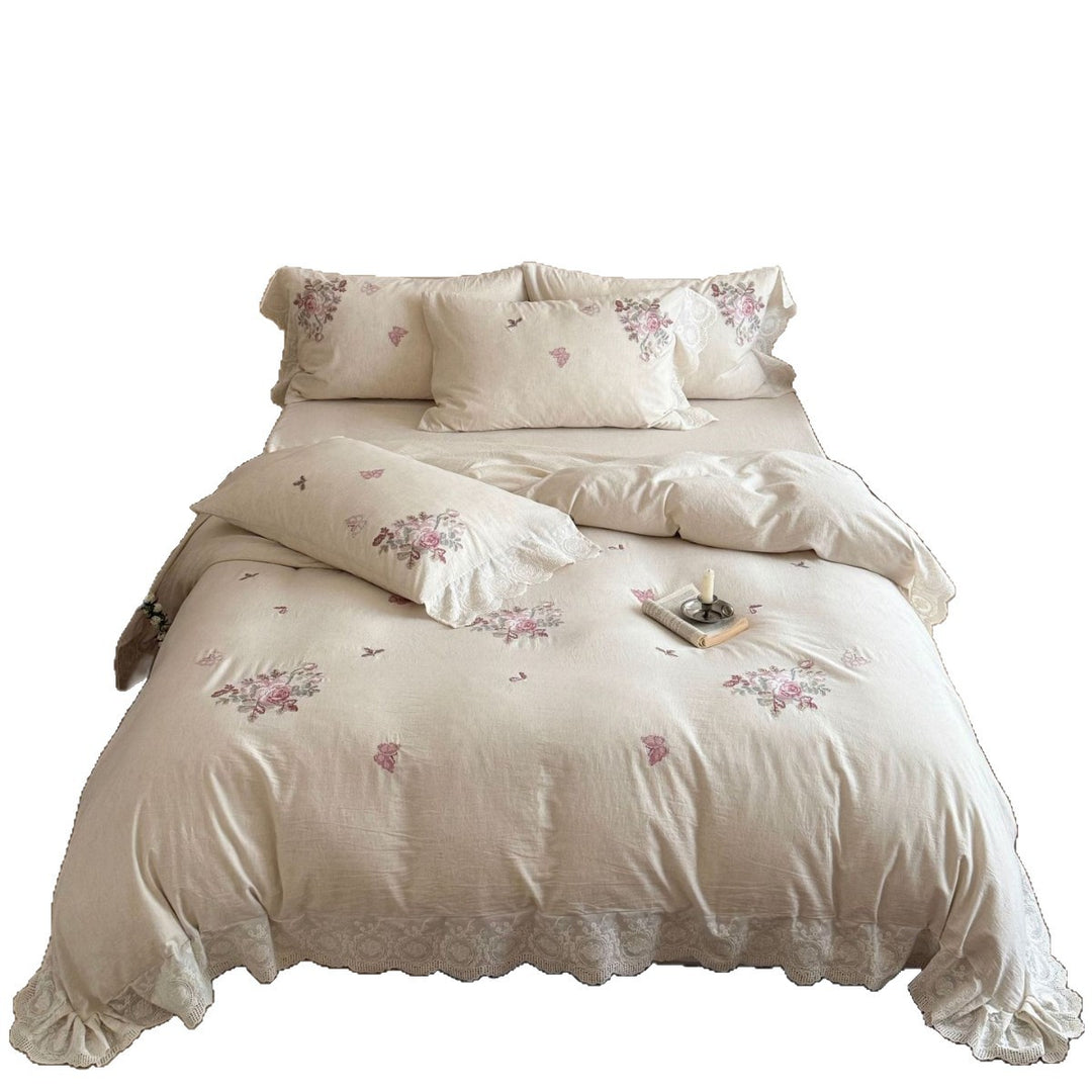 Embroidered cotton-linen bedding set with rose motifs, lace ruffle, and natural texture