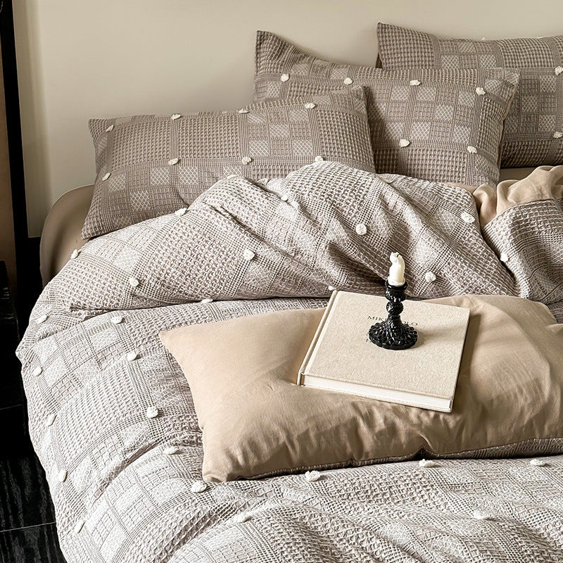 Luxurious cotton bedding set with textured waffle appearance and pompom details