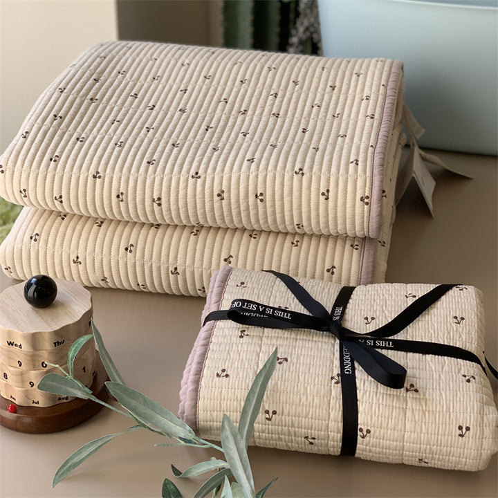 Padded children's bed pad and play mat made of quilted cotton with duck print