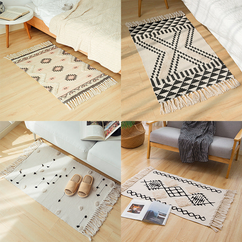 Hand-tufted bathroom mat with fringes, decorative dot-and-dash pattern and non-slip backing Kalsten