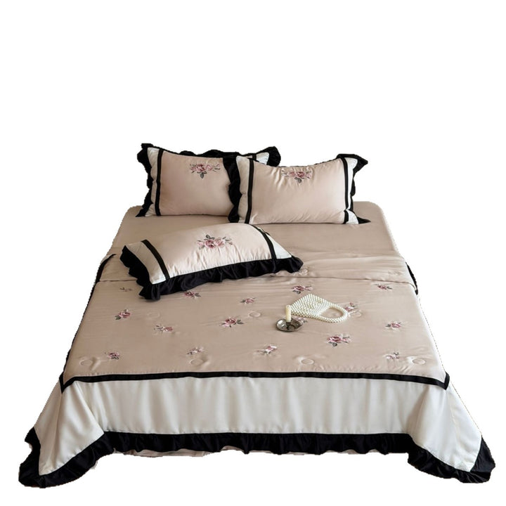 Satin duvet cover set with subtly embroidered roses, contrasting piping and ruffled hem