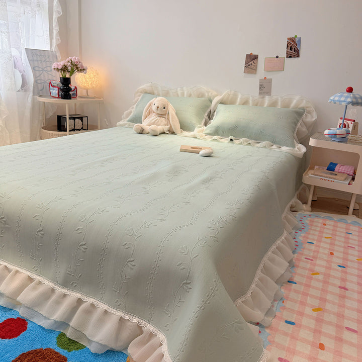 Quilted bedspread with ruffle and delicate floral quilting