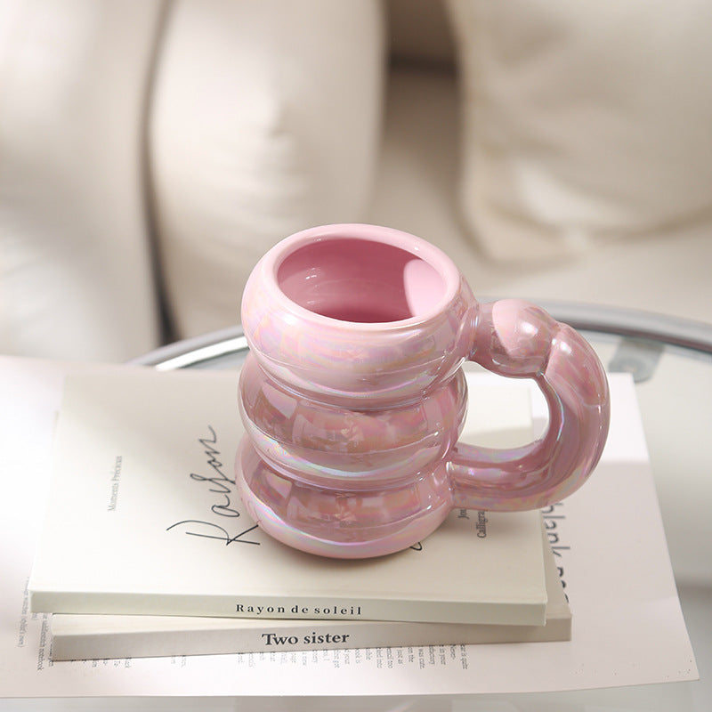 Sculptural ceramic mug with iridescent glaze and curved ring handle