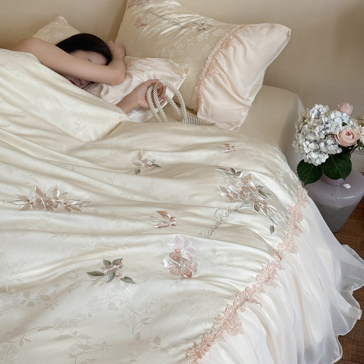 Romantic satin bedding set with embroidered floral design, ruffle and pillowcases