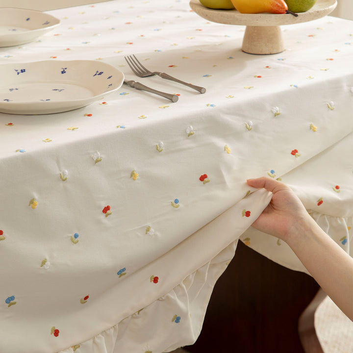 Embroidered tablecloth with ruffle and delicate floral relief