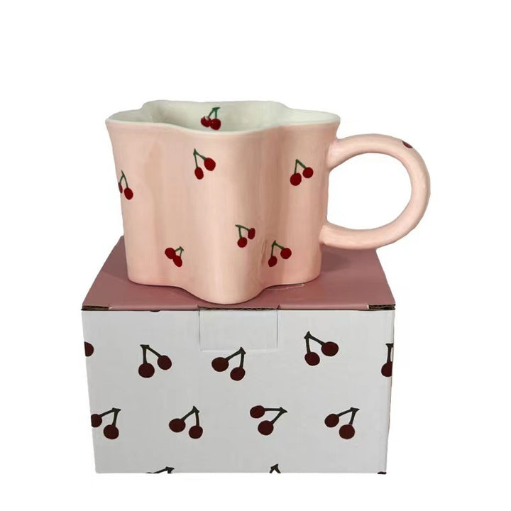 Ceramic coffee mug with flower-shaped wavy rim, illustrative banana decor and ergonomic handle