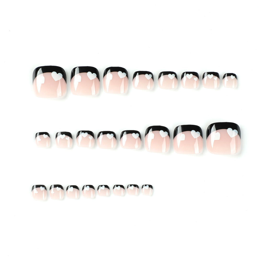 Artistic toenail design with heart motifs and modern black-and-white design Kalsten