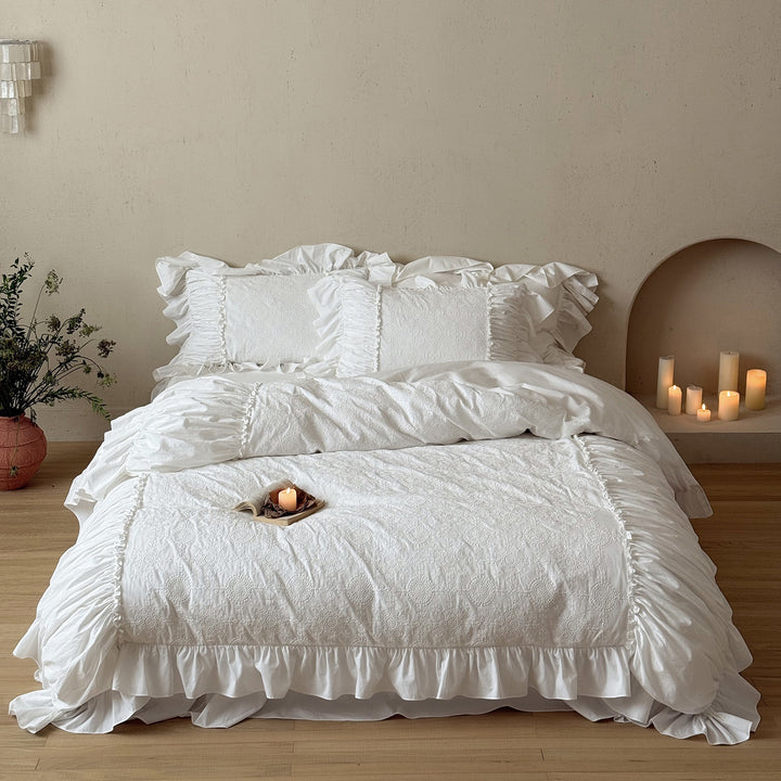 Romantic broderie anglaise bedding set with ruffle, quilted bedspread and decorative cushion