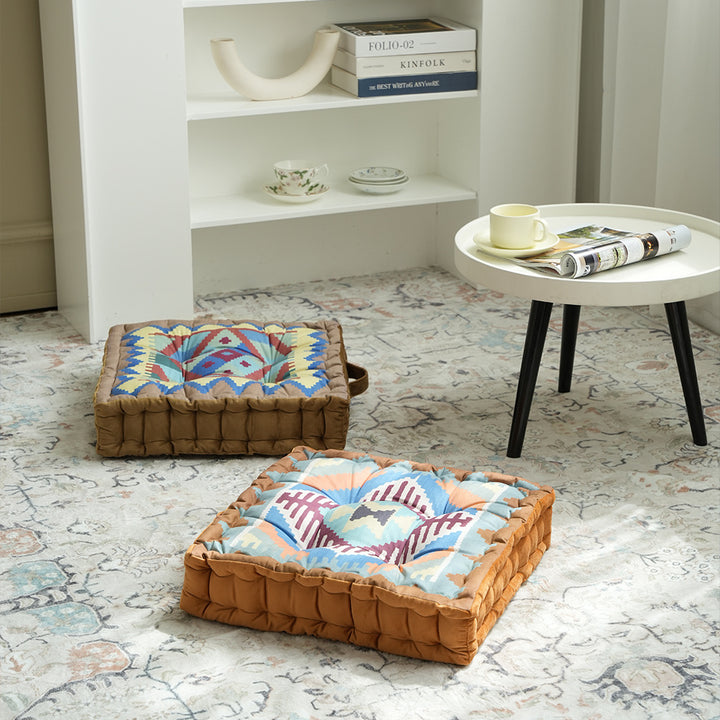 Square seat cushion with kilim-inspired pattern, quilted padding and carrying handle