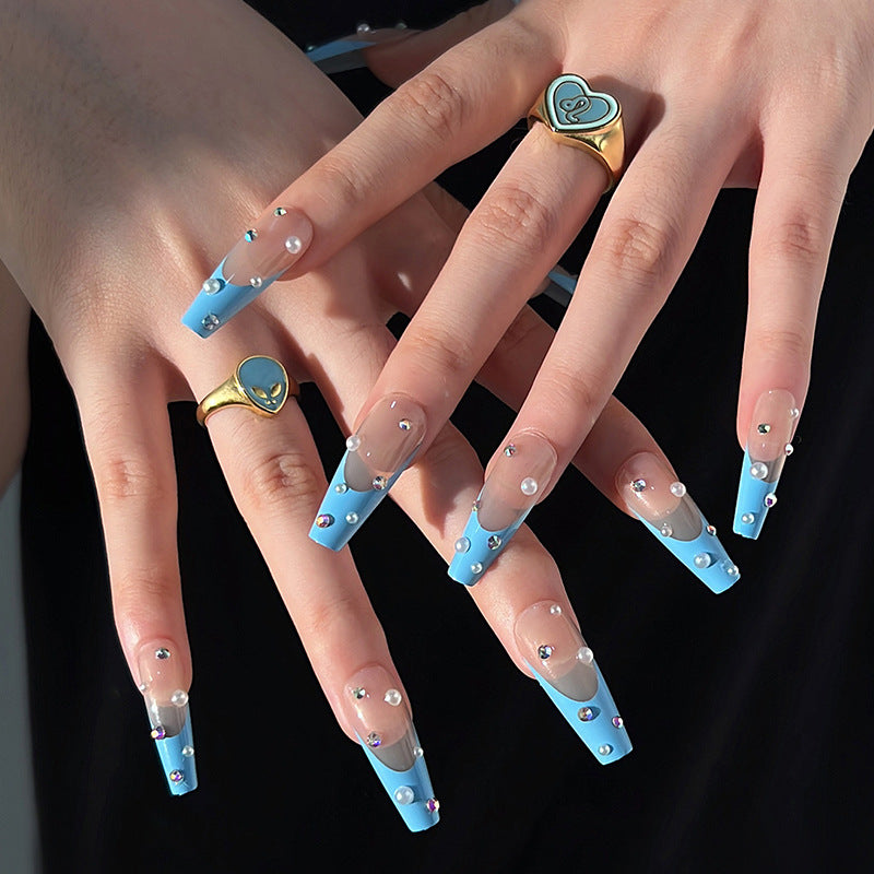 Artificial nail extensions with glitter and pearl accents Kalsten