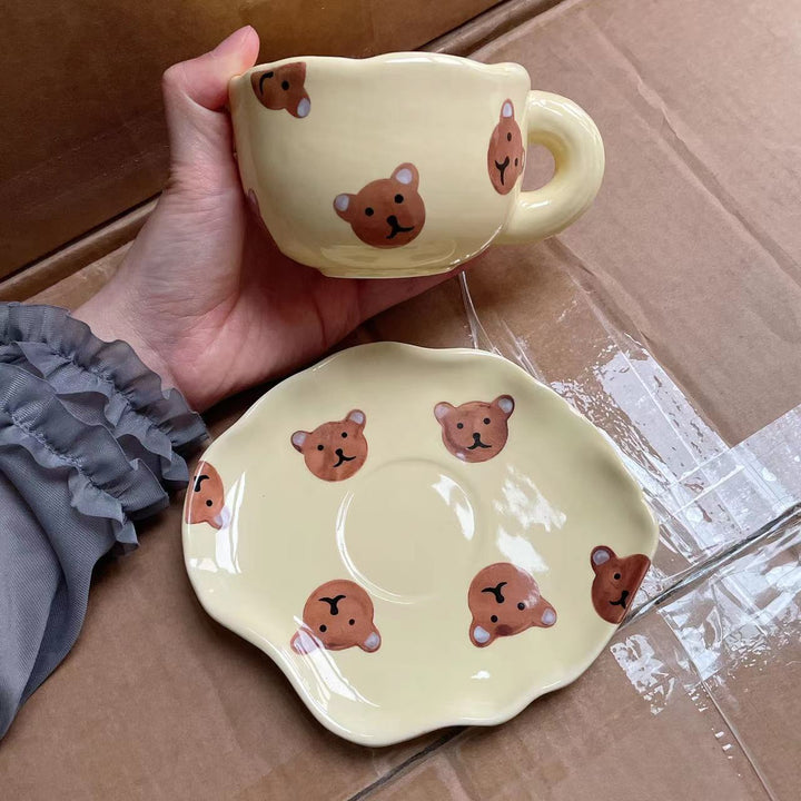 Ceramic coffee set with playful bear reliefs and organic wave saucer
