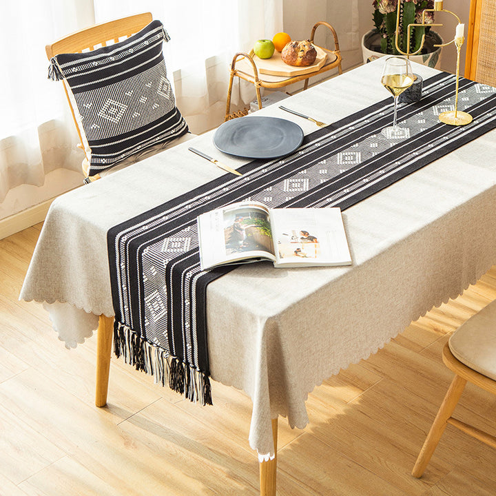 Handwoven table runner made of cotton blend with geometric weave pattern and fringe trim