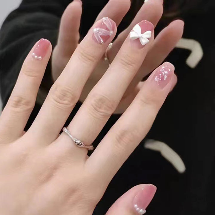 Glamorous nail art with pearl and bow accents Kalsten