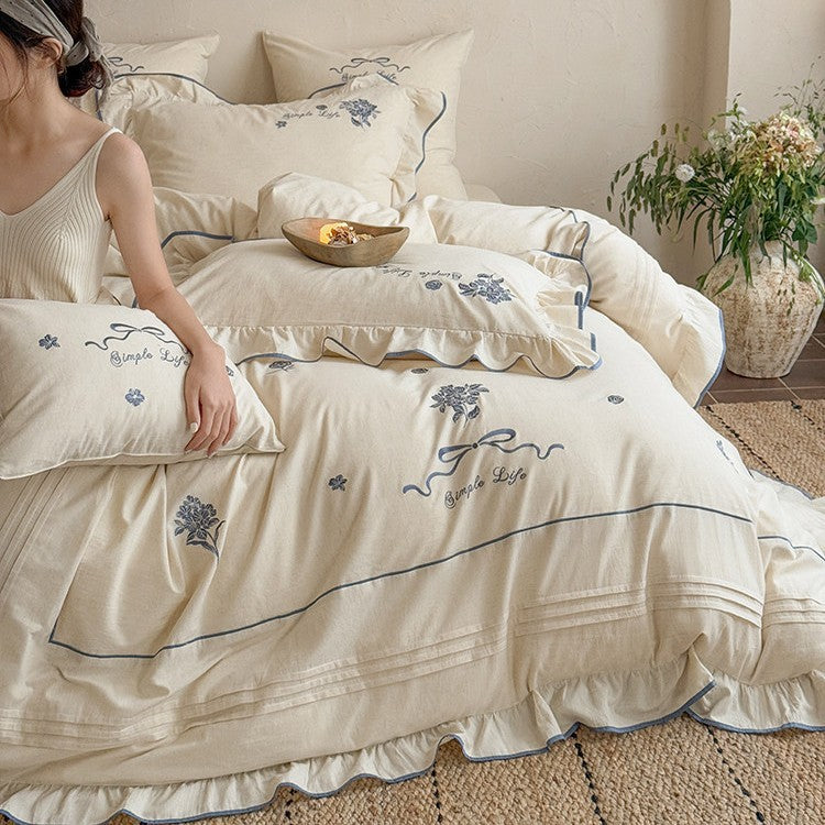 Cotton muslin bedding set with delicate floral embroidery, ruffle, and breathable finish