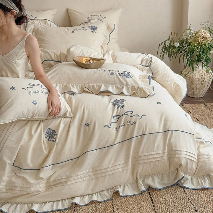 Cotton muslin bedding set with delicate floral embroidery, ruffle, and breathable finish