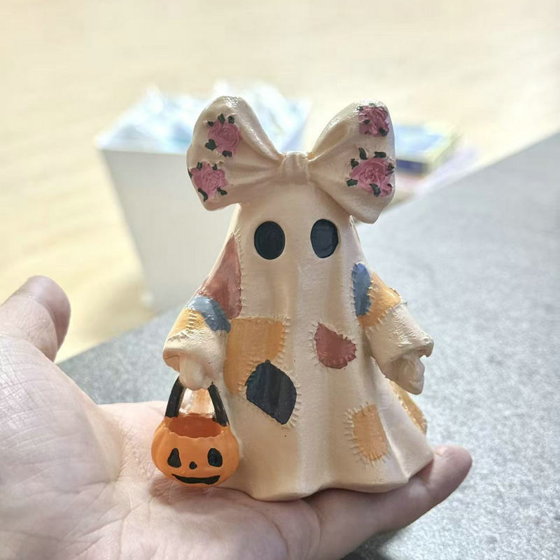Ceramic ghost figure with integrated lighting and pumpkin basket