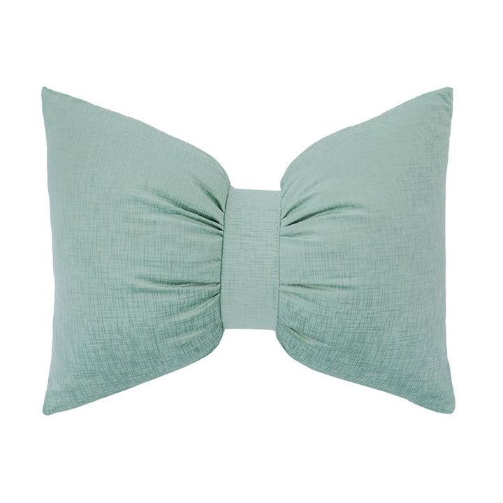 Bow-shaped decorative cushion with central band detail and structured fabric look