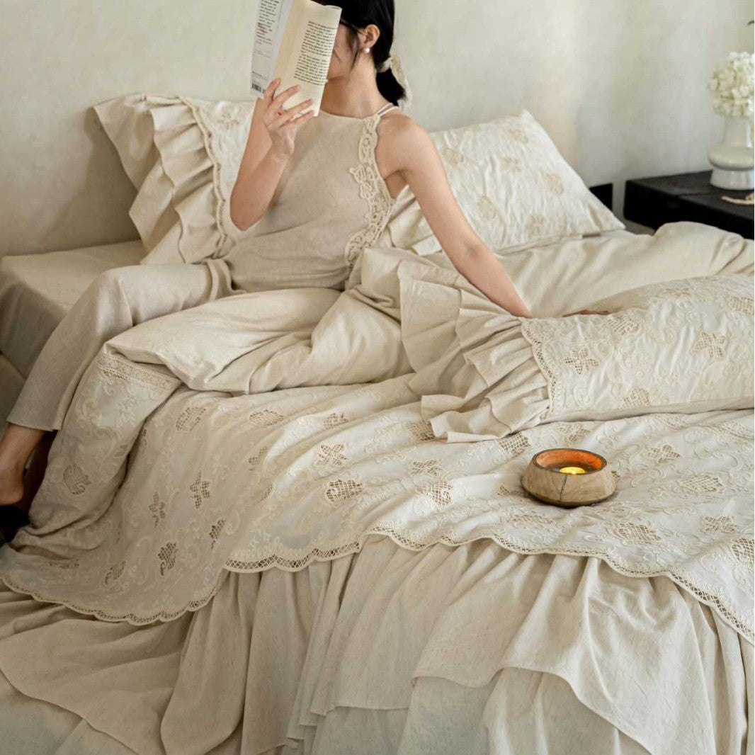 Romantic cotton bedding set in country house style with embroidered bedspread, ruffled bed skirt, and frill pillow.