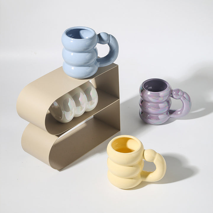 Sculptural ceramic mug with iridescent glaze and curved ring handle