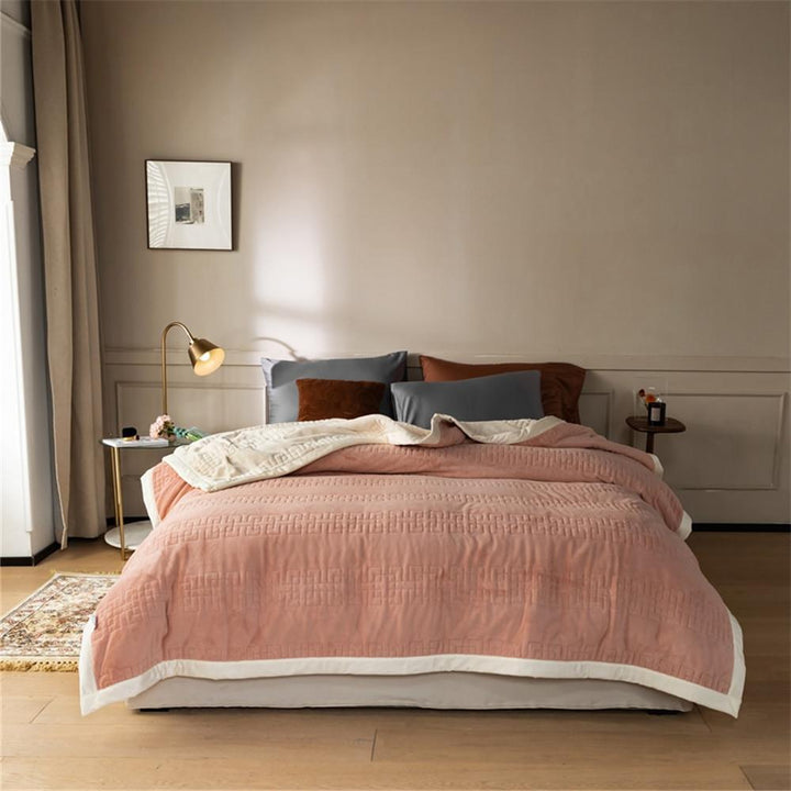 Reversible quilted comforter with structured box stitching and cotton trim
