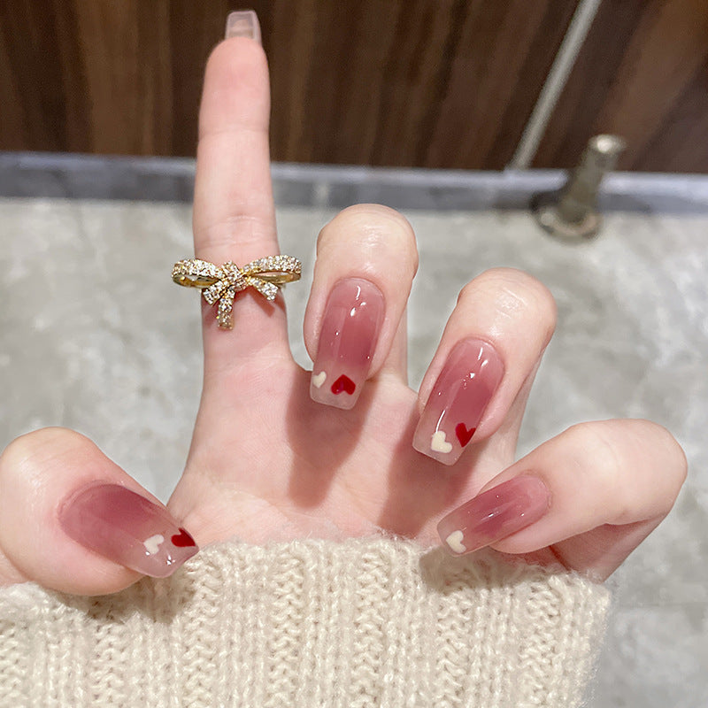 Glamorous artificial nails with heart design and glittering accents Kalsten