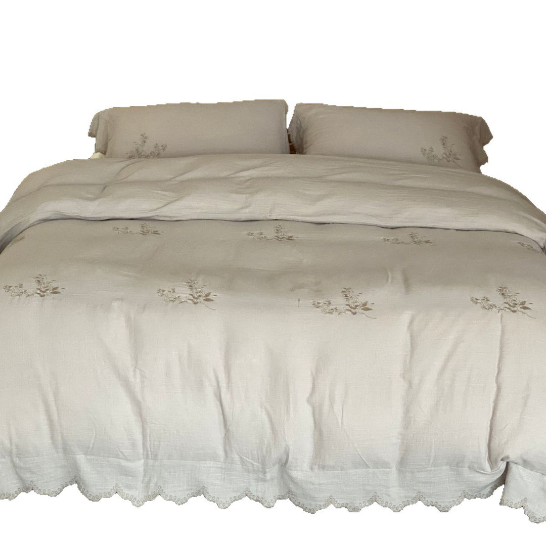 Linen look bedding set with floral embroidery and wavy hem